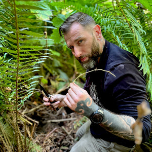 jon osiris in a patch of sword fern showing off a root of devils club